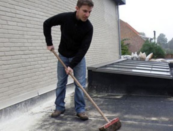 Un homme en train de nettoyer une toiture plat