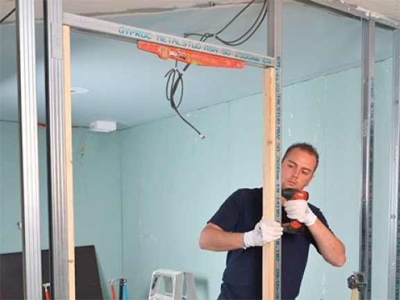 Fixer des lattes en bois dans l'embrasure de la porte
