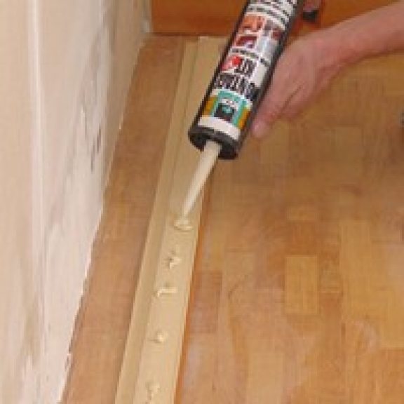 Appliquer de la colle de montage sur la plinthe
